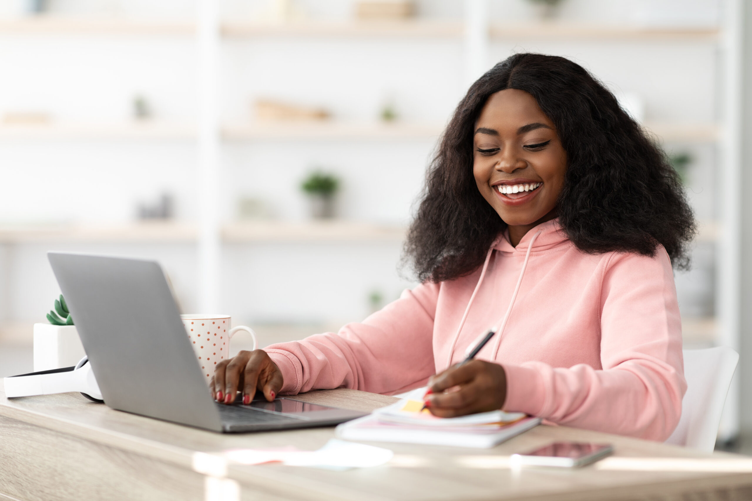 Smart black woman attending online class from home, using laptop